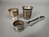 trois tasses en argent et une cuillère posées sur une table