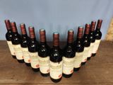 six bottles of red wine lined up in a row on a wooden table