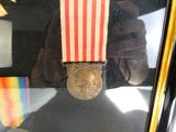 une médaille et une autre médaille exposées dans une vitrine