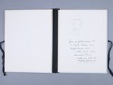 an open notebook with a drawing of a man ' s face on it