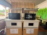 two microwaves sitting on top of each other in a room