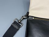 a close up of a black and white purse with a black strap