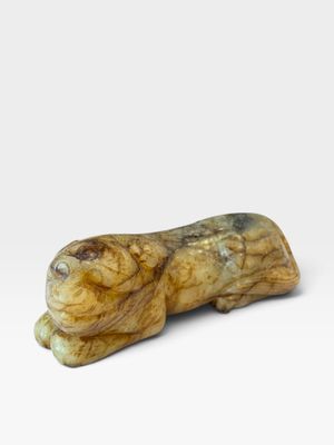 un gros plan d'une petite figurine d'animal posée sur une surface blanche