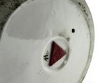 a white vase with a red triangle on it
