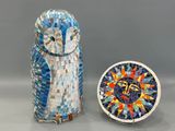 un petit hibou posé à côté d'une petite horloge sur une table