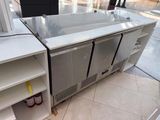 a refridgerator that is sitting on the floor next to a shelf