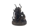 une statue en bronze représentant un homme et une femme assis sur un rocher