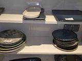 many plates and pans on the shelves in the kitchen