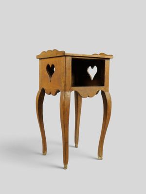 une petite table en bois dans laquelle un cœur a été découpé