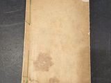 an old book sitting on a table with a bookmark on it