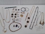 many different necklaces and bracelets displayed on a table