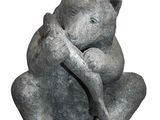 a statue of a bear that is sitting on a rock