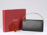 a black and red purse next to a red box on a white surface