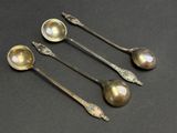 four spoons are sitting next to each other on a table