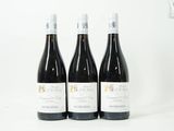 trois bouteilles de vin posées sur une table blanche