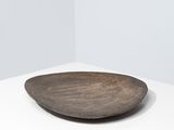 a close up of a wooden plate on a white surface