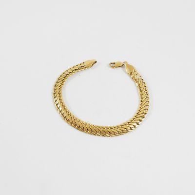 une image d'un bracelet en or sur fond blanc
