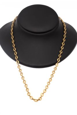 un chapeau noir et un collier à chaîne en or sur un mannequin