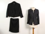 un tailleur noir et une jupe posés sur un présentoir à mannequin