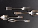 three silver spoons and two silver forks on a black surface