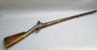un fusil au canon en bois et aux garnitures en laiton, sur fond blanc