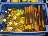 a blue bin filled with bottles of oil and other items