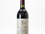 the bottle of wine is sitting on a white surface