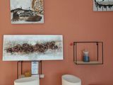 une pièce avec une table, des chaises et des tableaux accrochés au mur