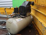 an air compressor sitting on the ground next to a yellow wall