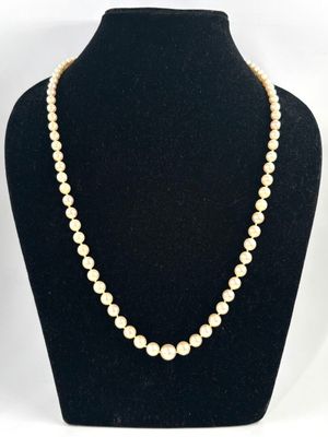 un collier de perles blanches sur un mannequin noir