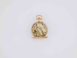 a close up of a gold pocket watch on a white surface