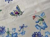 a white table cloth with blue flowers and a butterfly on it