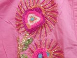 embroidered pink jacket with flowers and leaves on a pink background