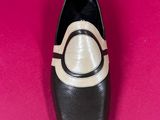 black and white shoes on a pink surface with a pink background