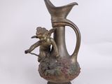 une statue représentant un Cupidon tenant une fleur dans un vase