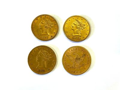 quatre types différents de pièces d'or sur une surface blanche