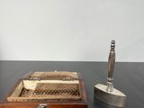a small wooden box with a pen and a candle on a table