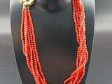 a close up of a necklace on a mannequin with red beads