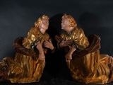 pair of antique bronze figurines of two women sitting on a black surface