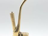 un vieux porte-pipe en laiton d'où sort une pipe