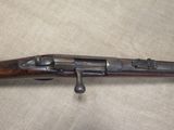 a close up of a rifle with a wooden handle on a table