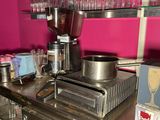 a counter with a coffee maker and cups on it