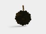a close up of a black flower pendant on a white background