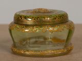 a green glass box with a gold decoration on it