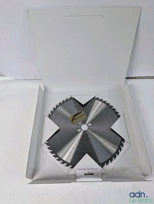 an open box with a saw blade inside of it on a white surface