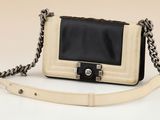 a white and black handbag with a chain strap
