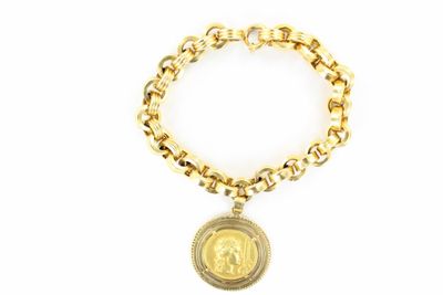 a close up of a gold bracelet with a coin on it