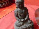a small statue of a buddha sitting on a table