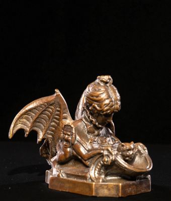 figurine en bronze représentant un enfant ailé sur fond noir