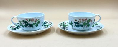 deux tasses et soucoupes ornées de fleurs, posées sur une table